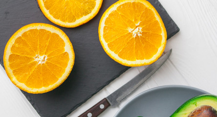 avocado , orange and lime on stone board