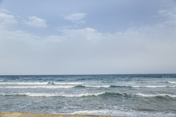 scorcio di mare con onde su cielo azzurro