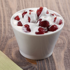 Strawberry with ice cream in a dish on a wooden table