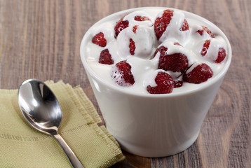 Strawberry with ice cream in a dish on a wooden table