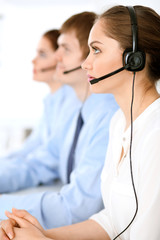 Call center operators. Focus at brunette business woman in headset