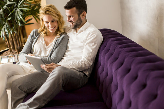 Couple with tablet on sofa