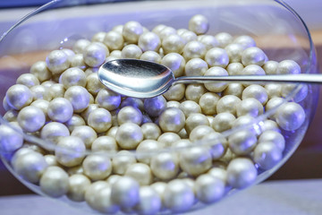 Confetti per bomboniera su bicchiere di vetro e cucchiaio.