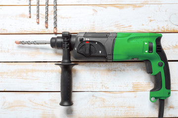 Electric hammer drill lies on a wooden table