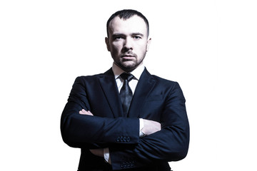Serious determined handsome young businessman / banker / lawyer with hands crossed in a business...