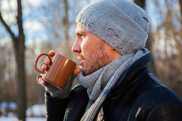 Handsome young man is traveling. He is looking forward in the forest at the nature. Blured...