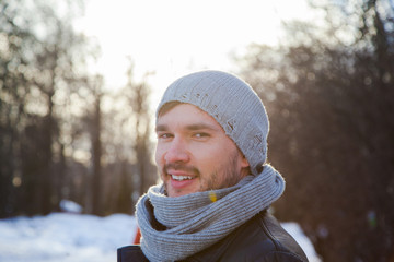 Handsome young man is traveling. He is looking forward in the forest at the nature. Blured background. He is froze.