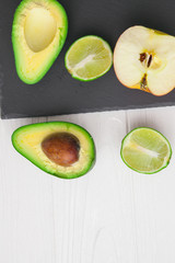 avocado ,apple and lime  on stone board 