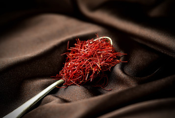 Saffron spice in spoon on velvet