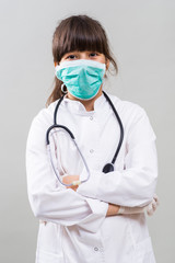 Portrait of little doctor on gray background.