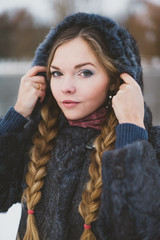 woman in a blue winter fur coat standing on the street in full growth