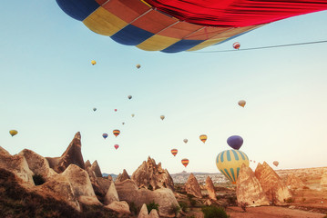 Fototapeta premium Hot air balloon flying over rock landscape at Turkey. Cappadocia