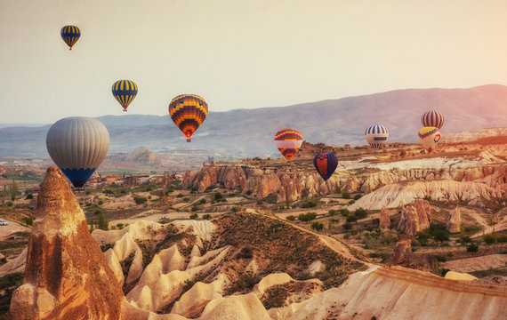 Hot air balloon flying over rock landscape at Turkey. Cappadocia