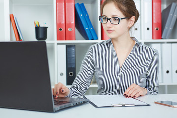 Beautiful young businesswoman working  on a laptop in the office. Business, exchange market, job...