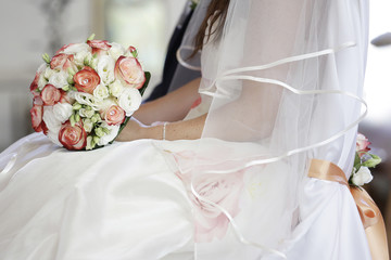 Sposa tiene in mano bouquet da matrimonio durante la messa © alex.pin