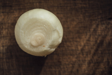 Peeled onion  on dark cutting board 