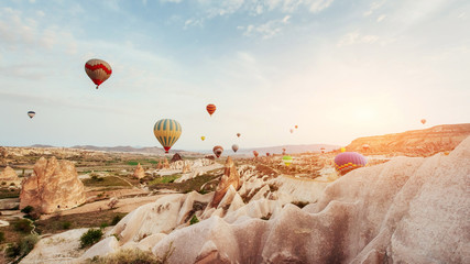 Hot air balloon flying over rock landscape at Cappadocia Turkey. - obrazy, fototapety, plakaty