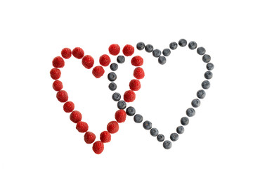 Fresh berries lying in two heart shapes isolated in white