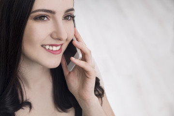 Close up of woman in beige on phone