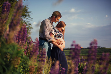 Happy beautiful girl pregnant with her husband outdoor.