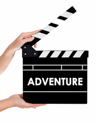 Hands holding a clapper board with ADVENTURE text