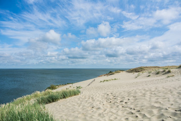 A view of the sand dunes with grass and a fence at Nida, Lithuania.