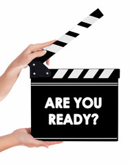 Hands holding a clapper board with ARE YOU READY text