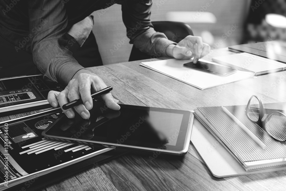 Aufkleber website designer holding smart phone and working computer digital tablet on wood table