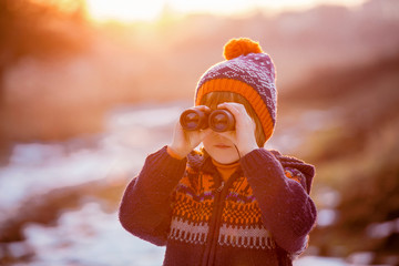 Cute little child, boy, exploring nature with binoculars © Tomsickova