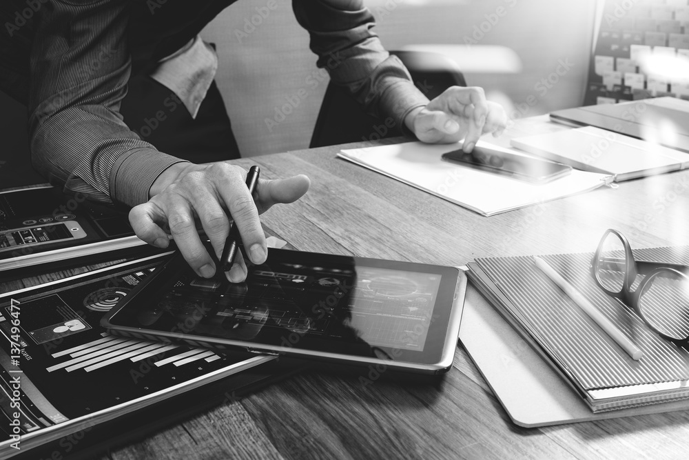 Aufkleber website designer holding smart phone and working computer digital tablet on wood table,black white