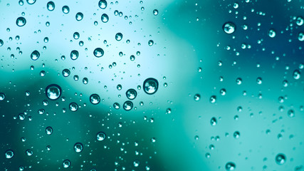 Water droplet on a mirror and green blurred bokeh background in vintage style.