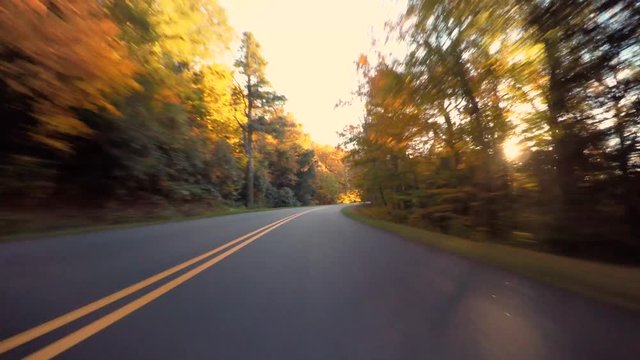 Autumn POV driving shot of the Blue Ridge Parkway through North Carolina at sunset