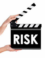 Hands holding a clapper board with RISK text