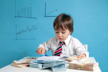 Young boy, counting money and taking notes