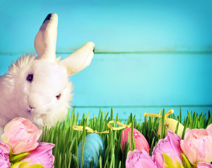Little Easter bunny on green grass and flowers