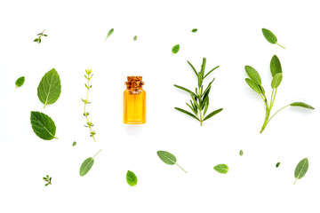 Bottle of essential oil with fresh herbal sage, rosemary, lemon thyme ,thyme ,green mint and...
