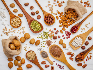 Various legumes and different kinds of nuts in spoons. Walnuts kernels ,hazelnuts, almond ,brown...