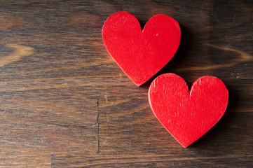 Two red wooden heart on a wooden background. Space for text