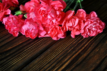 Różowe goździki na tle rustykalnych desek  © bnorbert3