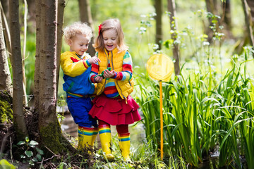 Children playing outdoors catching frog