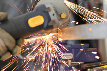 Man Cutting Metal with Machine Flying Fire Sparks