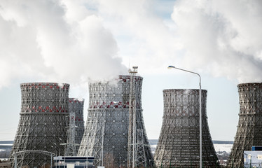 Nuclear power plant. Big cooling towers or pipes. Thick white smoke. 