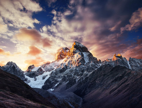 Autumn landscape and snow mountains in beautiful cumulus clouds.