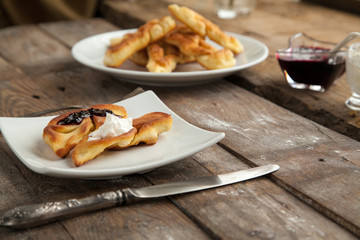 Homemade fritter with berry syrup on wooden background. Sweet breakfast for children that everyone would like.