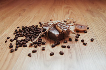 Organic soap with coffee beans and spices, on wooden background.