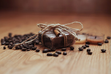 Organic soap with coffee beans and spices, on wooden background.