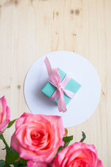 gift and three roses on white background