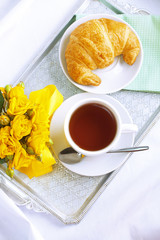 Morning breakfast with croissant and tea.