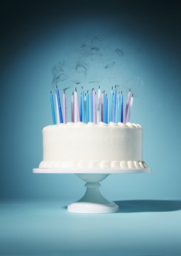 Candles blown out on birthday cake against blue background