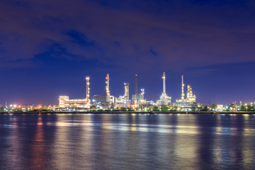 Oil refinery on water front at night